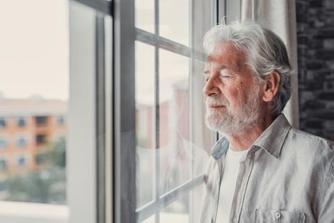 wertvollER: Prostatakrebspatient steht mit geschlossenen Augen am Fenster wertvollER: Prostatakrebspatient steht mit geschlossenen Augen am Fenster